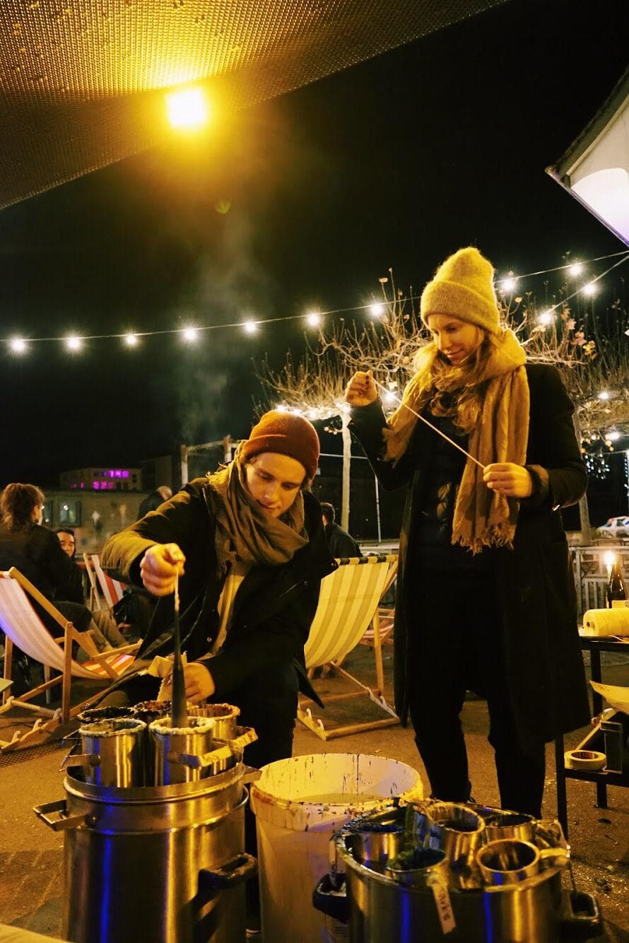 Zwei Menschen am Kerzenziehen 